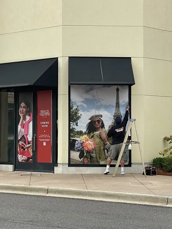 Wide Open Signs team installing large scale retail storefront window graphics