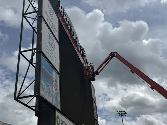 Aerial installation work on an outdoor stadium sign