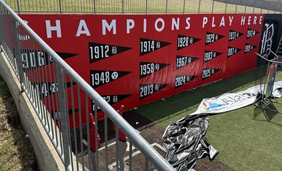 Enormous red Champions Play Here banner with championship years installed at Regions Field
